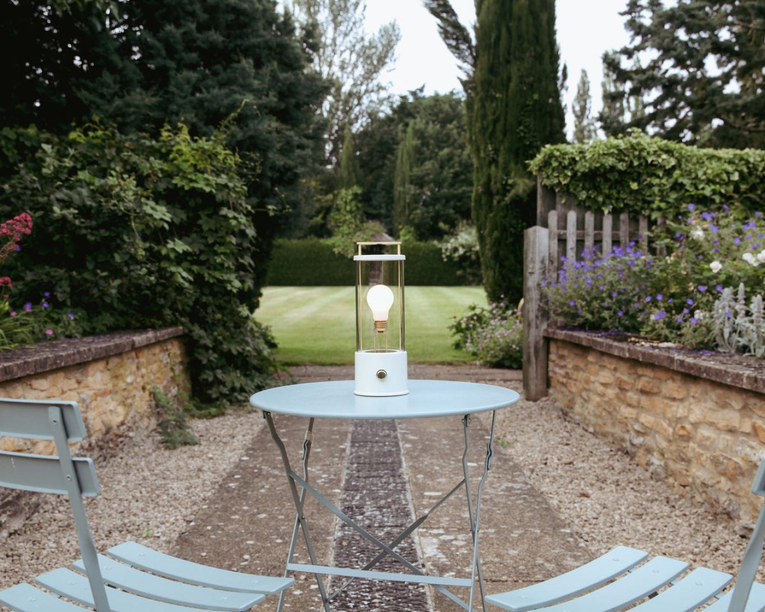 The Muse Portable Lamp in Candlenut White on an outdoor conversation set