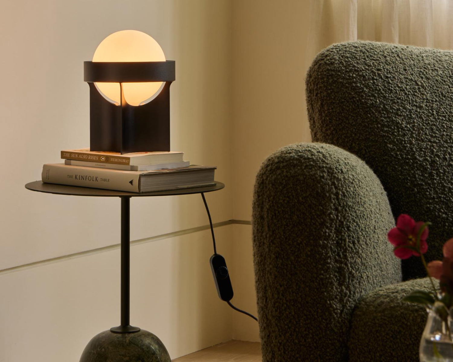 Loop Table Lamp in Dark Grey next to an armchair in a small living room setting