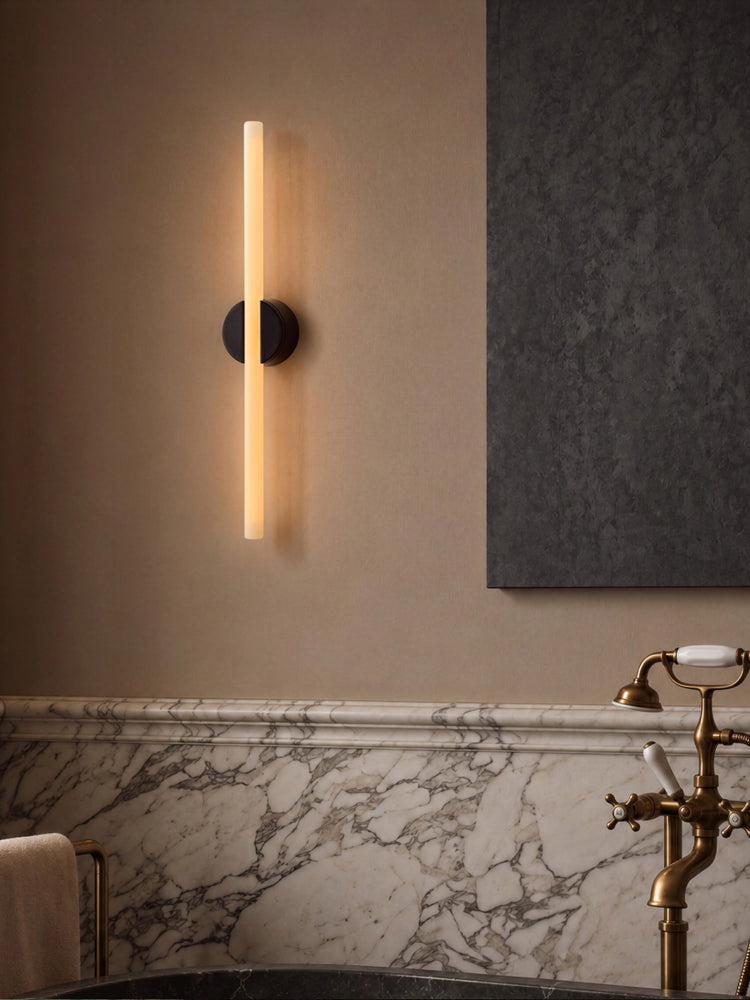 The Muse Portable Lamp in Solid Brass next to a bathtub in a bathroom setting. The Muse is the perfect self care companion, portable to any space and providing a perfect glow to set the mood anywhere.
