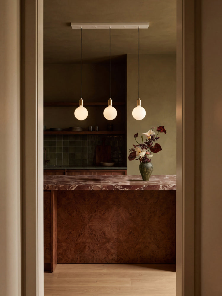 Linear Triple Pendant + Voronoi II lighting up a kitchen island setting. Tala's linear pendants are perfect for elongated kitchen spaces, elevating the space beautifully.